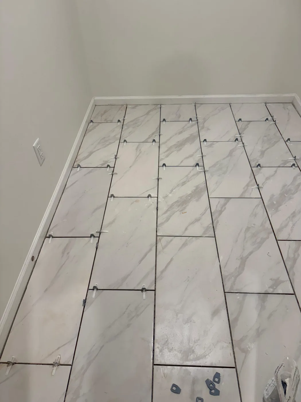Large-format marble-look tile being set level